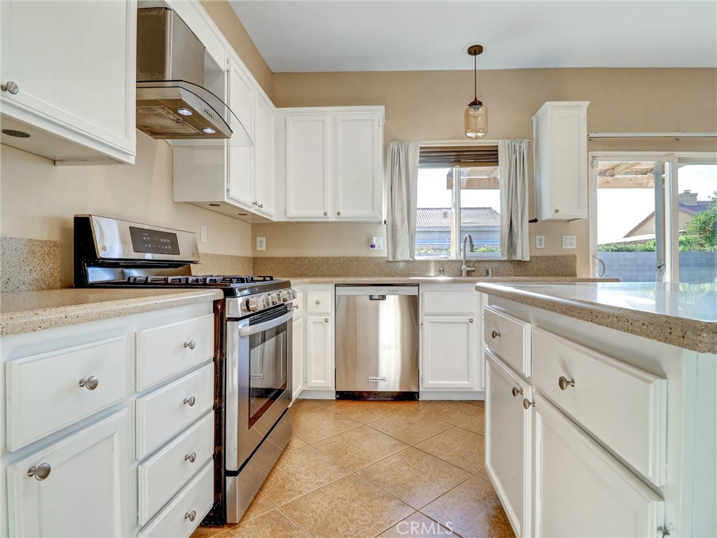 47718 Phoenix Street Indio, CA 92201 - Photo 24 of 54 a kitchen with granite countertop white cabinets and white stainless steel appliances