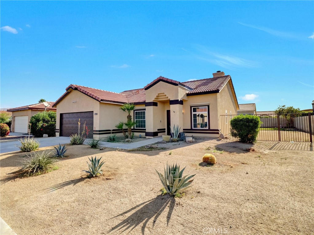 47718 Phoenix Street Indio, CA 92201 - Photo 9 of 54 a view of a house with snow on the road and wooden fence