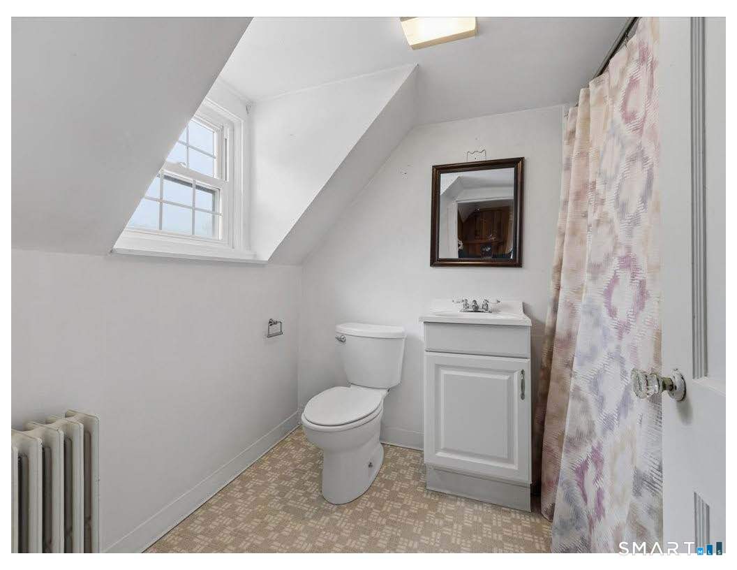 195 Bokum Road Old Saybrook, CT 06475 - Photo 15 of 30 a bathroom with a toilet a sink a mirror a window and vanity