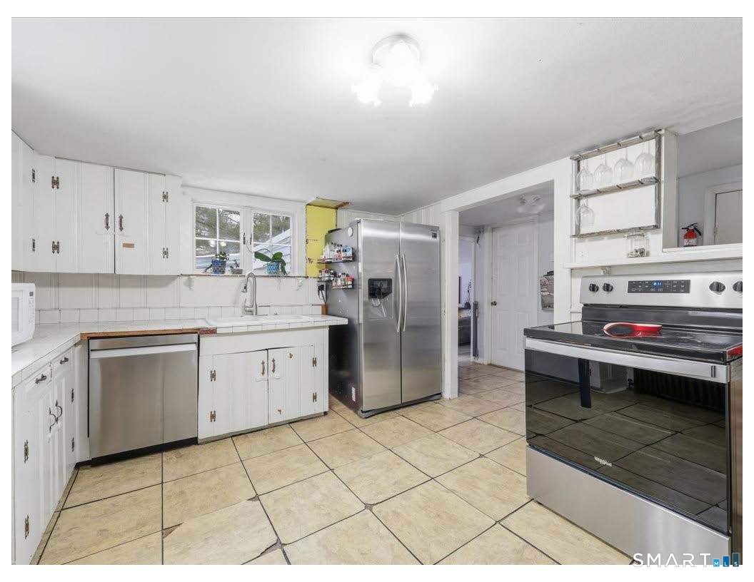 195 Bokum Road Old Saybrook, CT 06475 - Photo 7 of 30 a kitchen with a sink cabinets and stainless steel appliances