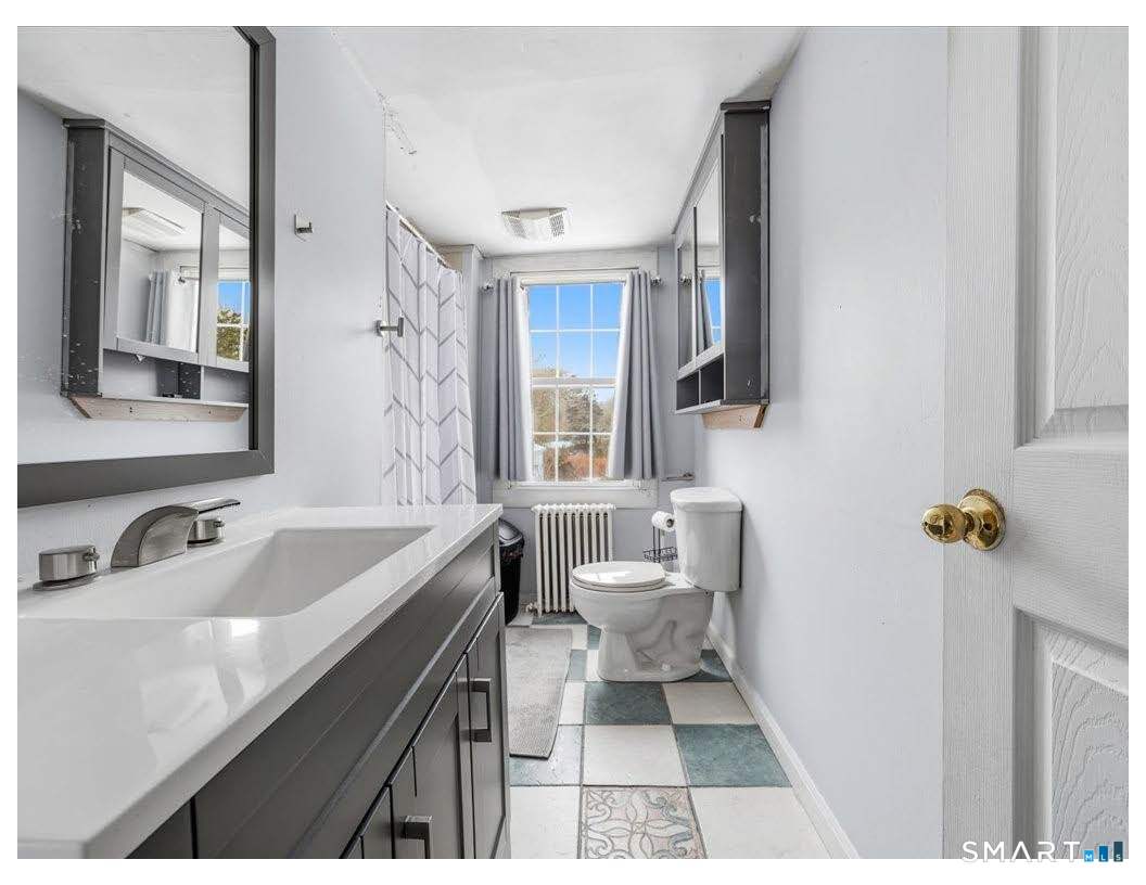 195 Bokum Road Old Saybrook, CT 06475 - Photo 9 of 30 a bathroom with a sink and a large mirror