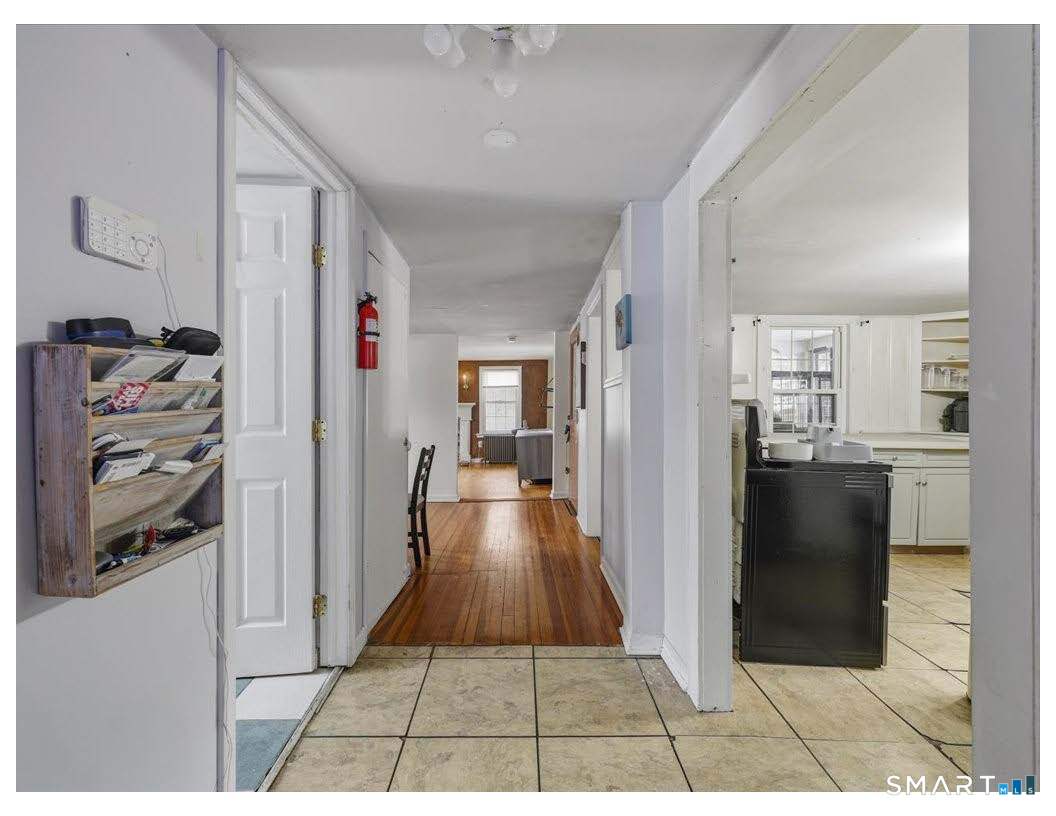 195 Bokum Road Old Saybrook, CT 06475 - Photo 10 of 30 a view of a hallway with wooden floor and a living room
