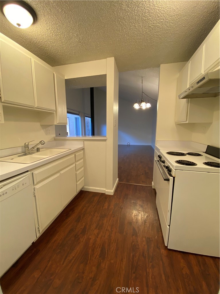 7890 East Spring Street, Unit 19A Long Beach, CA 90815 - Photo 9 of 24 a view of cabinets and wooden floor