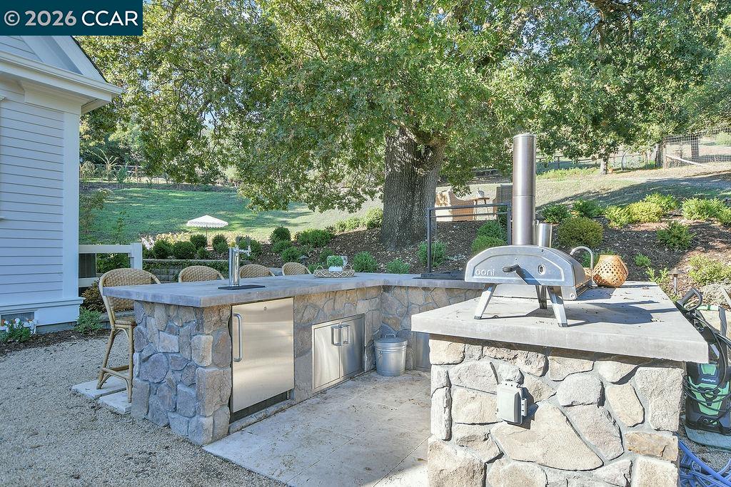 1751 Reliez Valley Road Lafayette, CA 94549 - Photo 32 of 60 a view of a patio with table and chairs potted plants and a large tree