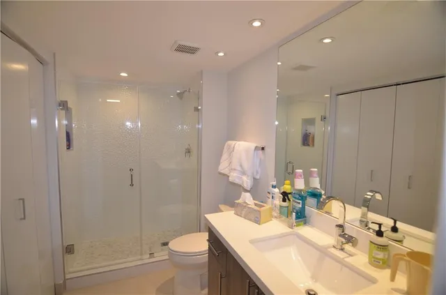 a bathroom with a bathtub shower sink vanity and toilet