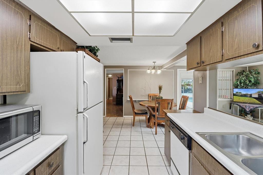 7410 Gulf Highlands Drive Port Richey, FL 34668 - Photo 17 of 45 a kitchen with stainless steel appliances granite countertop a sink refrigerator and cabinets