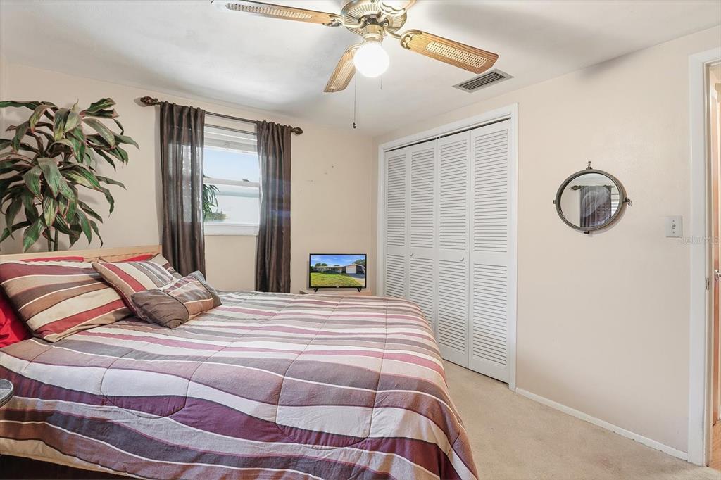 7410 Gulf Highlands Drive Port Richey, FL 34668 - Photo 26 of 45 a bedroom with a bed and a chandelier