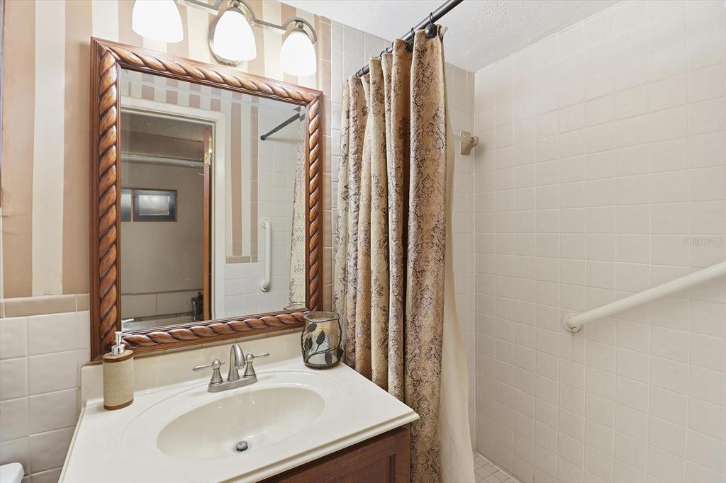 7410 Gulf Highlands Drive Port Richey, FL 34668 - Photo 33 of 45 a bathroom with a sink a mirror and a shower