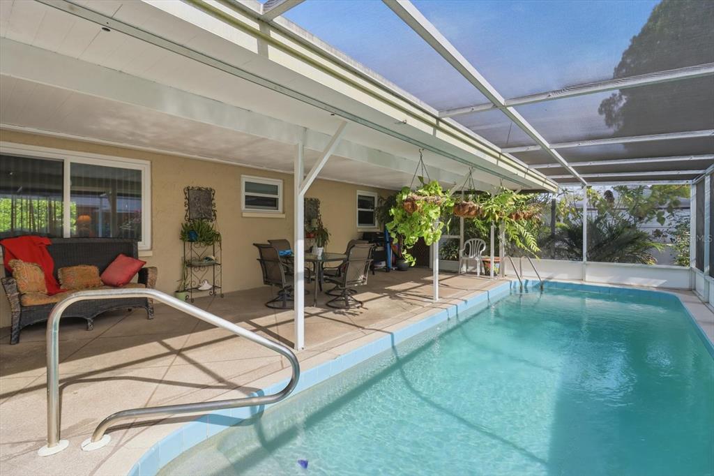 7410 Gulf Highlands Drive Port Richey, FL 34668 - Photo 38 of 45 a view of a patio with table and chairs potted plants with wooden floor