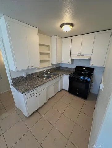 a kitchen with granite countertop white cabinets and appliances