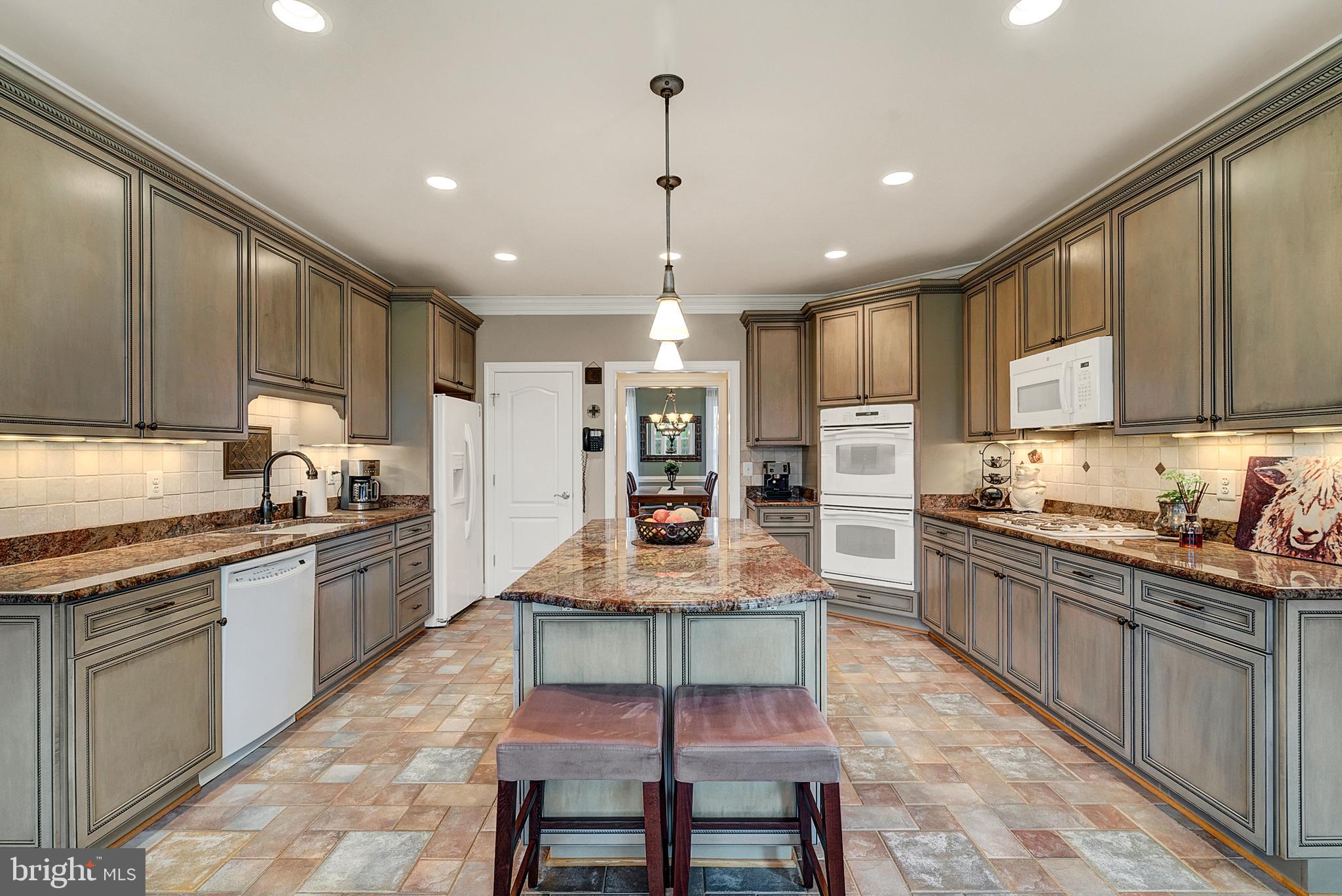 8633 Shepherds Way Rixeyville, VA 22737 - Photo 16 of 48 a kitchen with kitchen island granite countertop wooden cabinets and white appliances