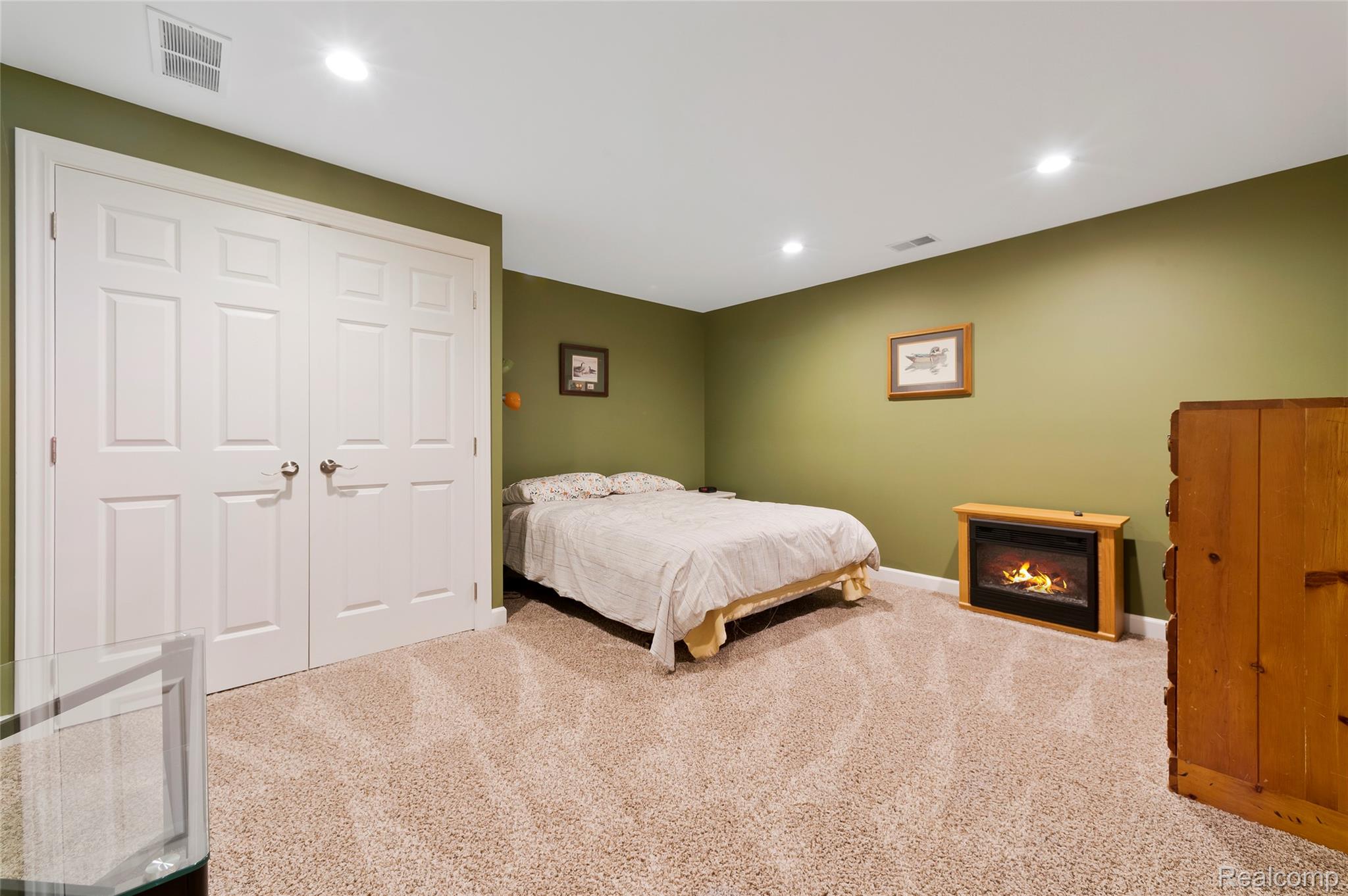 13085 Rohn Road Fenton, MI 48430 - Photo 28 of 52 Carpeted bedroom featuring a glass covered fireplace, recessed lighting, and a closet