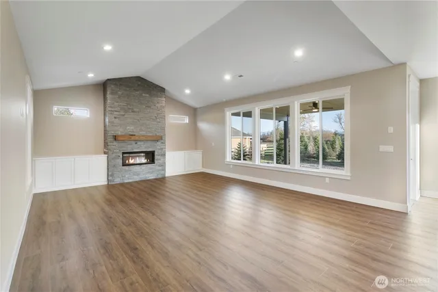 an empty room with wooden floor and a fireplace