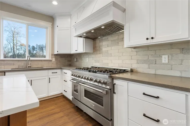 a kitchen with white cabinets and appliances