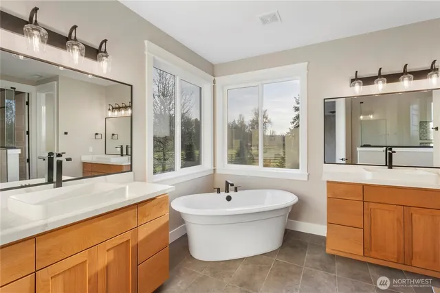 a bathroom with a double vanity sink a mirror and a bathtub