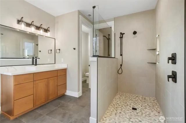 a bathroom with a double sink shower and a mirror
