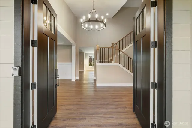 a view of a hallway with wooden floor and staircase