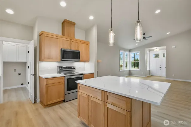 a kitchen with kitchen island a sink stainless steel appliances and cabinets