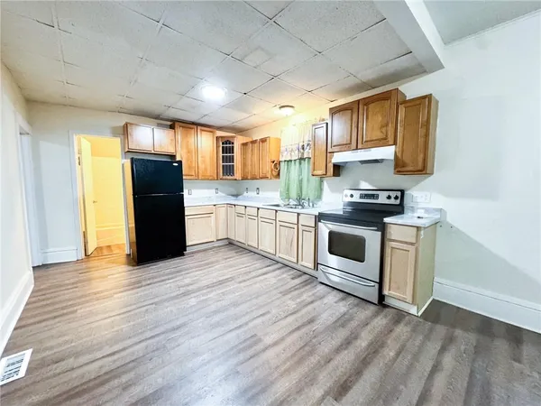 a kitchen with stainless steel appliances granite countertop a stove a sink and a refrigerator