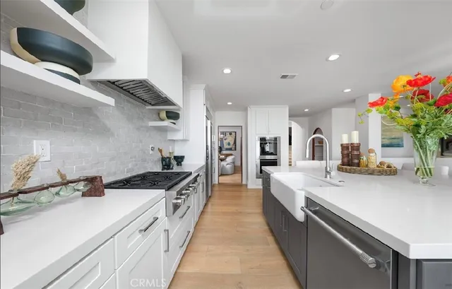 a large white kitchen with a stove and a sink