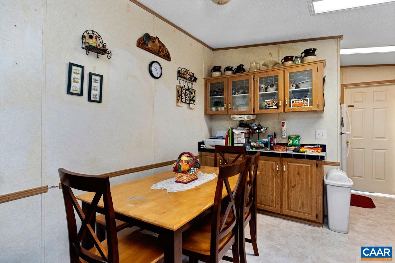 5000 Wheelers Cove Road Shipman, VA 22971 - Photo 18 of 45 a dining room with stainless steel appliances granite countertop a dining table and chairs with wooden floor