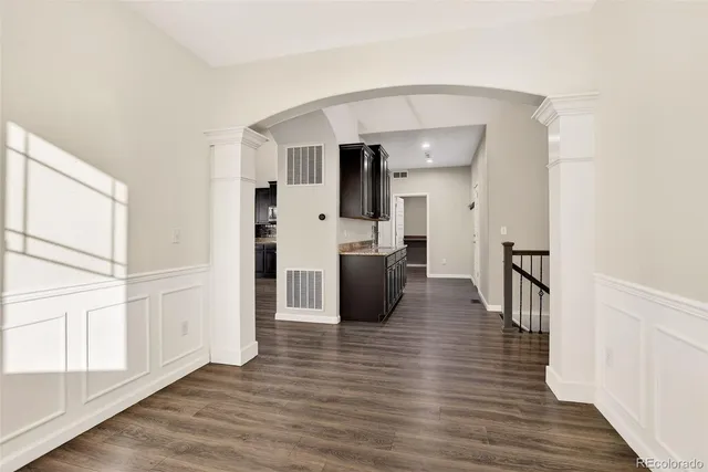 a view of a living room with furniture and wooden floor