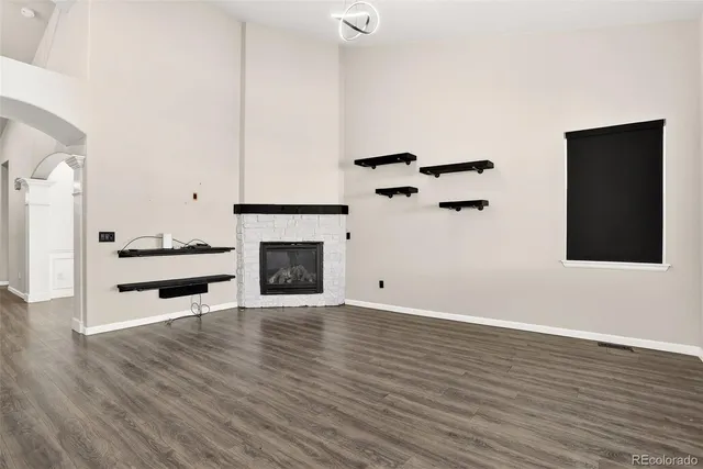 a view of a livingroom with wooden floor and a fireplace