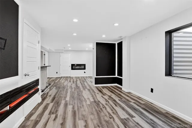 a view of a big room with wooden floor and windows