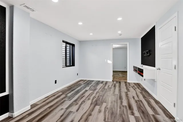 a view of a big room with wooden floor and windows