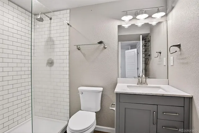 a bathroom with a sink vanity mirror and toilet