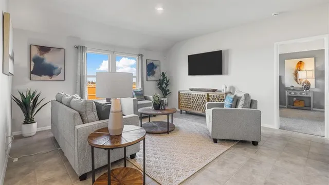 a living room with furniture and a view of kitchen