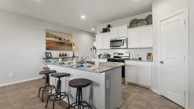 a kitchen with stainless steel appliances granite countertop a sink stove and cabinets