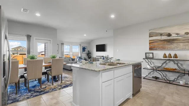 a kitchen with stainless steel appliances granite countertop a sink a stove a refrigerator and cabinets