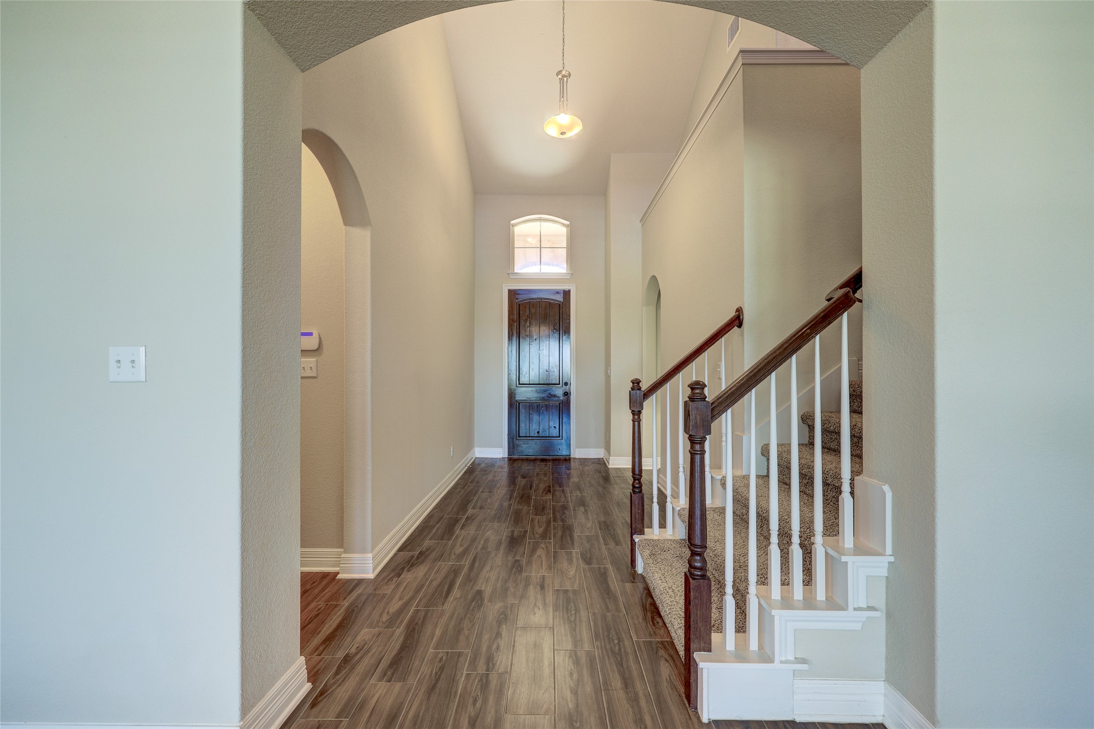 409 Betony Loop Buda, TX 78610 - Photo 5 of 38 Enter into a welcoming hallway featuring a striking front door and a gracefully designed staircase.