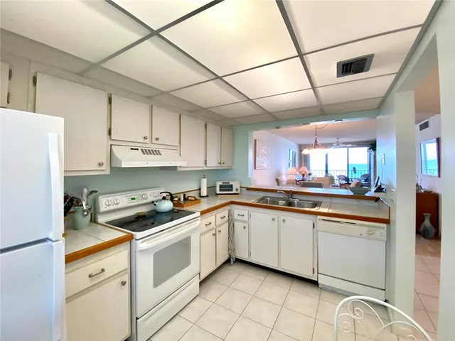 a kitchen with granite countertop white cabinets and white appliances