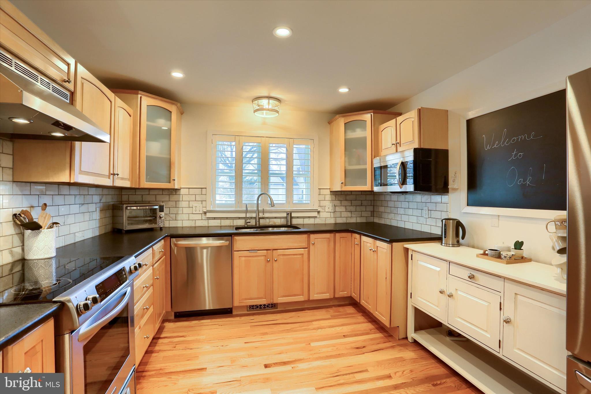 155 Oak Lane Hershey, PA 17033 - Photo 16 of 54 a large kitchen with stainless steel appliances granite countertop a sink and dishwasher a stove top oven with wooden floor