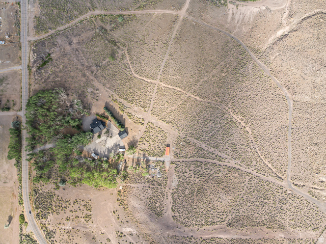 460 Omni Point Road Central Valley, UT 84754 - Photo 87 of 101 Expansive aerial view showcasing a property with a dark-roofed structure and a secondary building, surrounded by arid vegetation