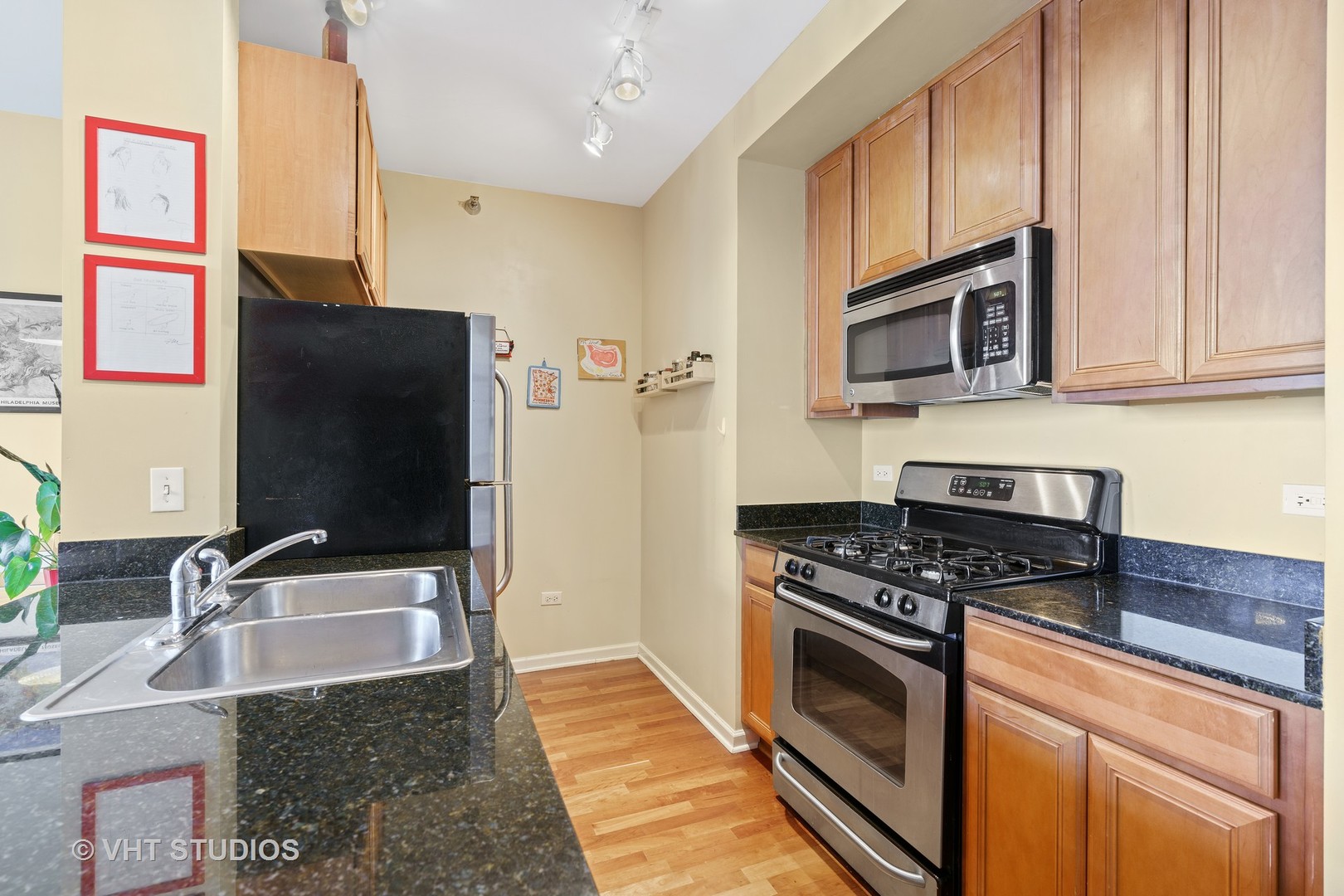 1255 South State Street, Unit 1809 Chicago, IL 60605 - Photo 5 of 11 a kitchen with granite countertop a sink stove and microwave