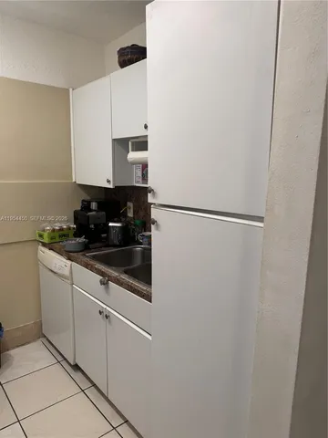 a kitchen with a refrigerator and cabinets