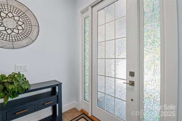 a view of a hallway with wooden floor and a potted plant