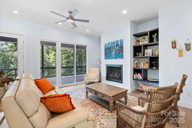 a living room with furniture a fireplace and a large window