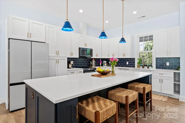 a kitchen with a white cabinets and chairs