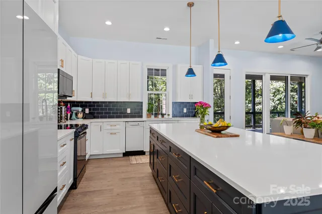 a kitchen with stainless steel appliances granite countertop a sink a stove and a refrigerator