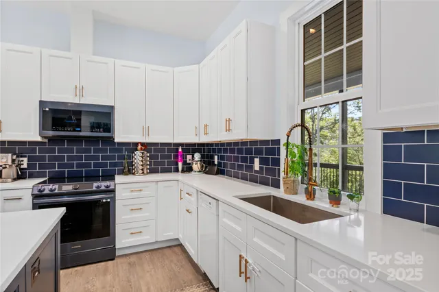 a kitchen with stainless steel appliances kitchen island granite countertop a sink a stove and cabinets