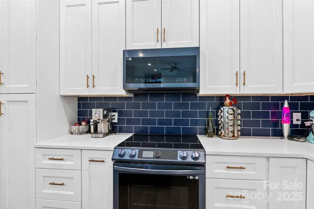 a kitchen with a stove and white cabinets