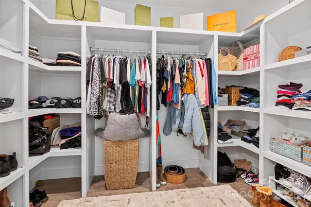 a view of walk in closet with clothes and shoes