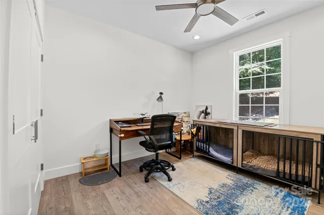 a view of a workspace with furniture and a window