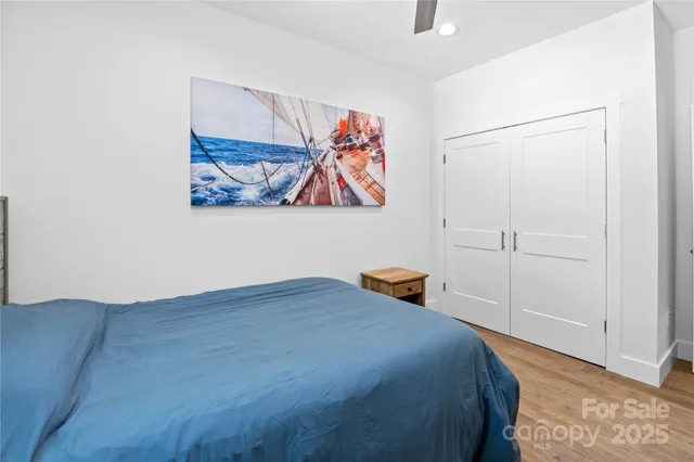 a bedroom with a bed and painting on the wall