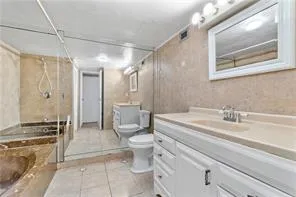 a bathroom with a granite countertop sink mirror vanity and toilet