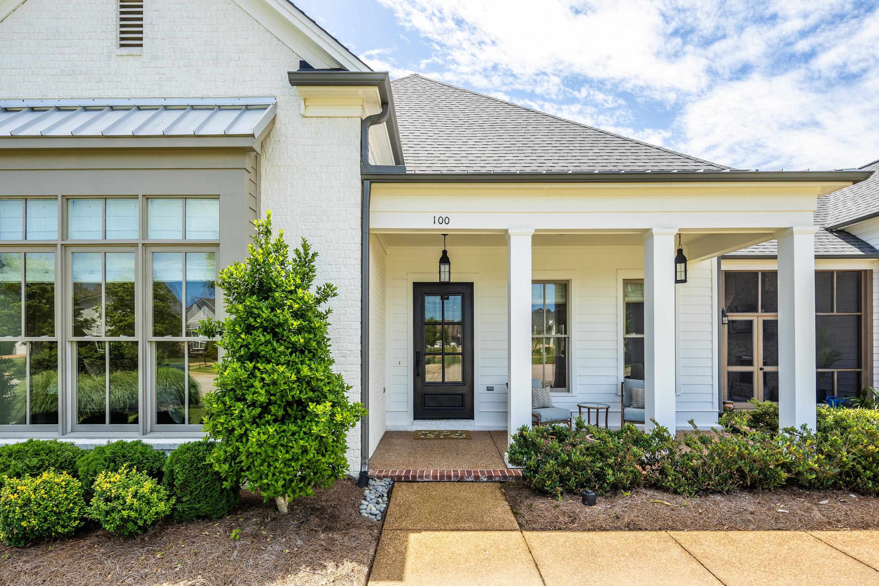 100 Sunflower View Road Piperton, TN 38017 - Photo 2 of 29 Exterior featuring white painted brick, a covered porch with white columns, a black front door with glass panes, a screened porch, and established landscaping